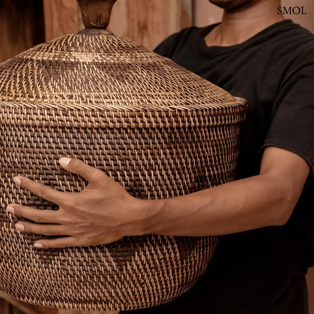Natúr barna rattan tárolókosár fedővel és faragott fa fogantyúval, 55×52 cm, férfi kezében, oldalról