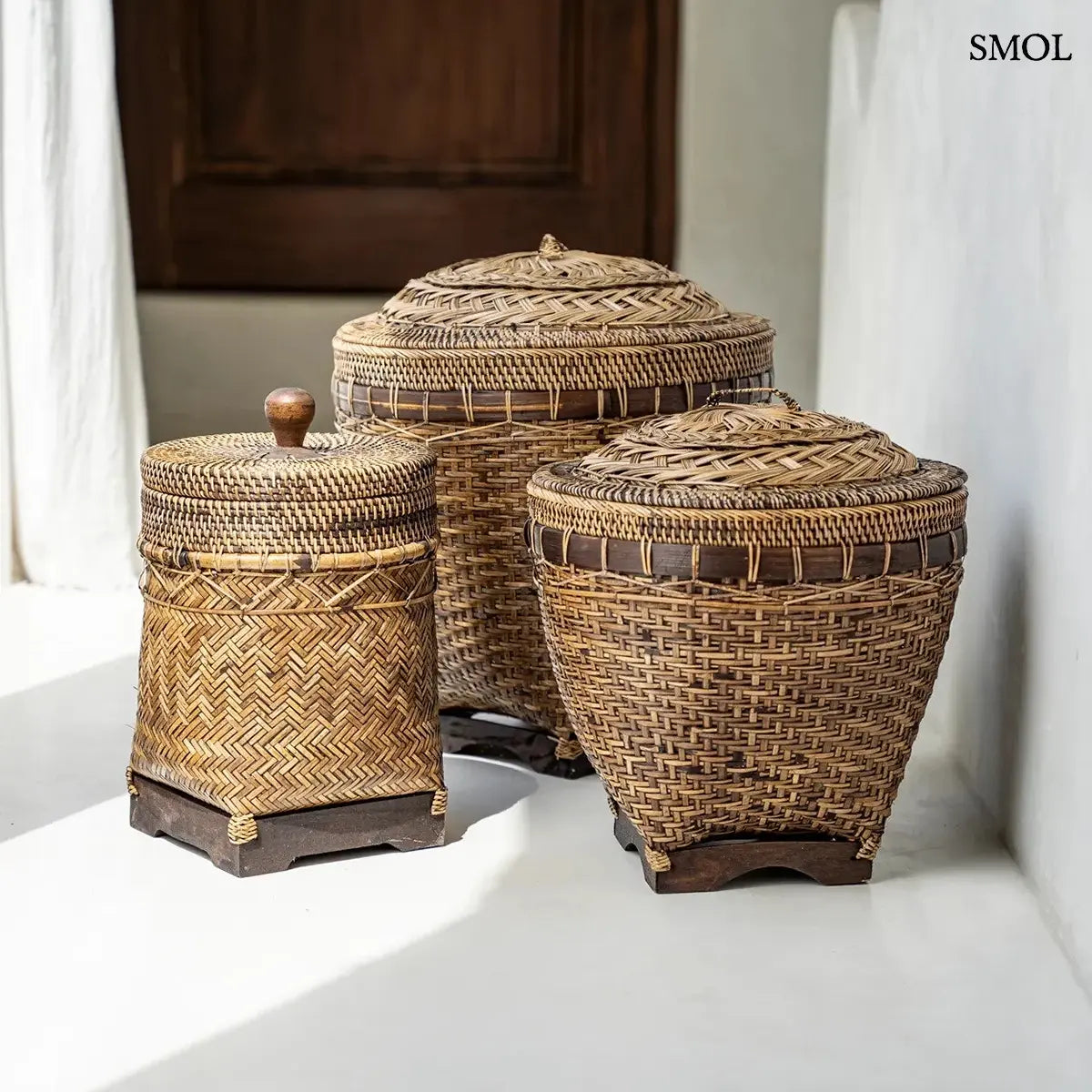 Barna rattan tárolókosár fedővel, halszálka fonásmintával és fa gombbal, 27×36 cm, három különböző kosár együtt