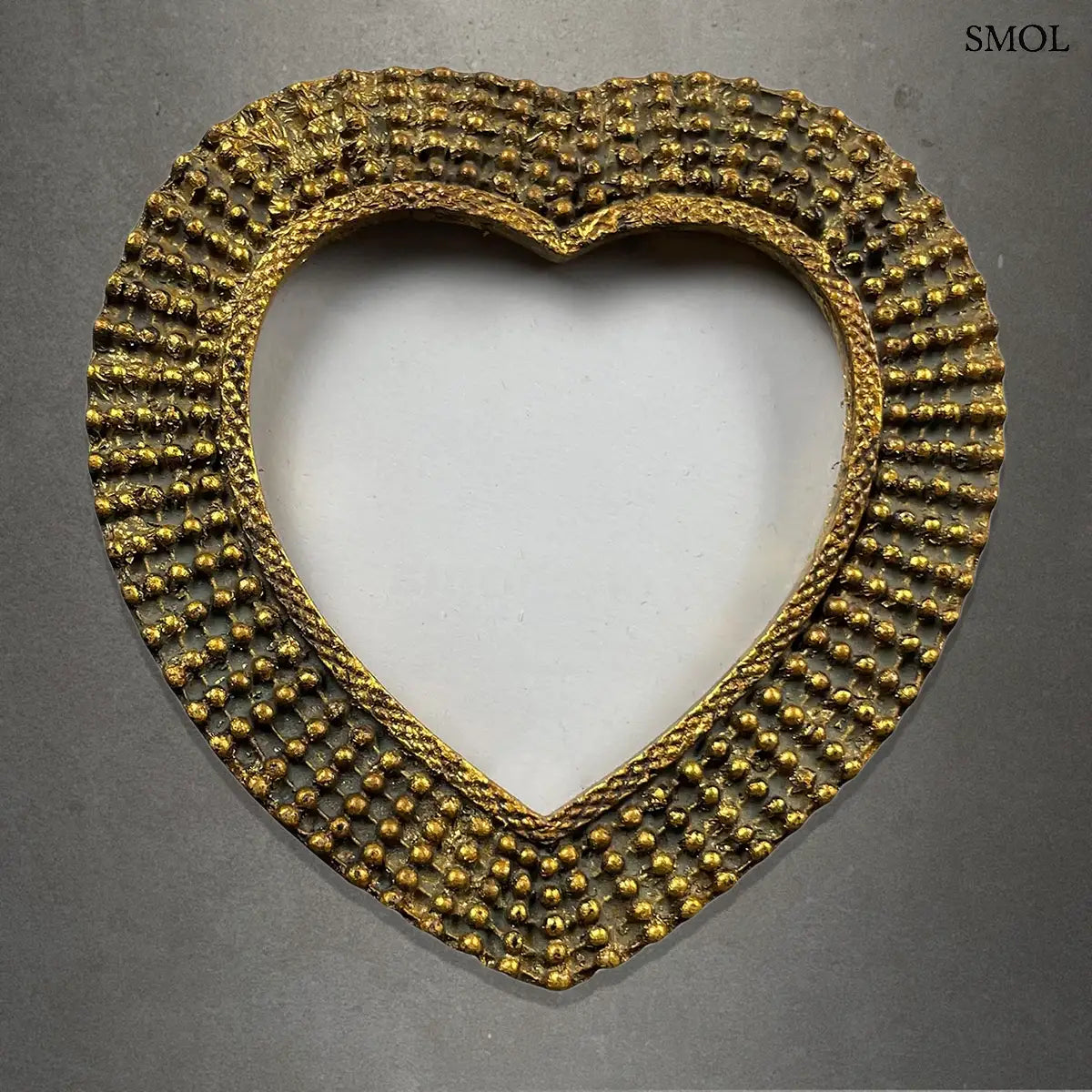 Antik arany szív képkeret gyöngyös díszítéssel és vintage textúrával, szürke háttérrel