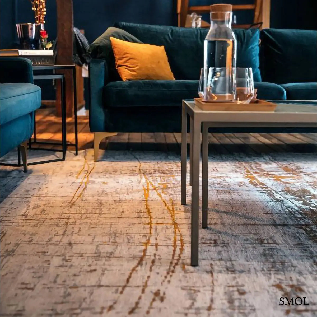 ECO RUG COLUMBUS GOLD absztrakt mintás szőnyeg arany alapon fekete-barna akcentusokkal, nappaliban, kanapéval
