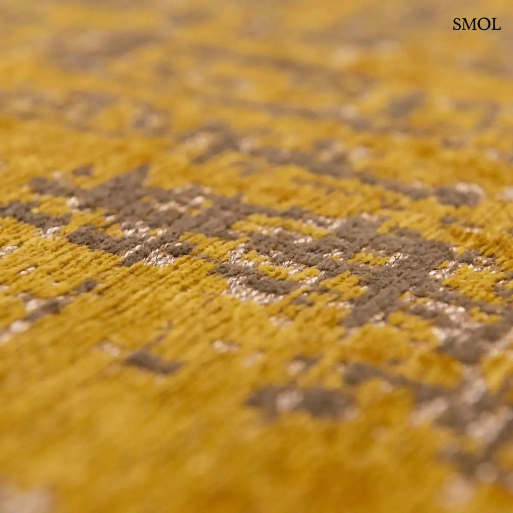 ECO RUG LIBERTY GOLD szőnyeg, aranyszín alapon sötétbarna és fekete festékszerű vonalakkal, action painting hatású mintázattal, textúra nagyítva