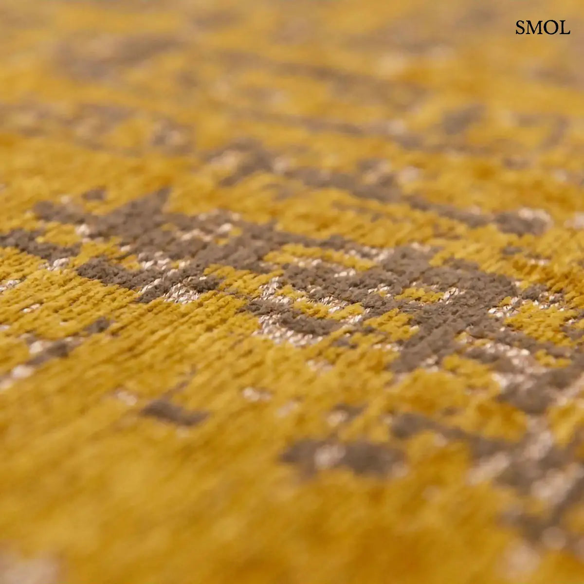 ECO RUG LIBERTY GOLD szőnyeg, aranyszín alapon sötétbarna és fekete festékszerű vonalakkal, action painting hatású mintázattal, textúra nagyítva