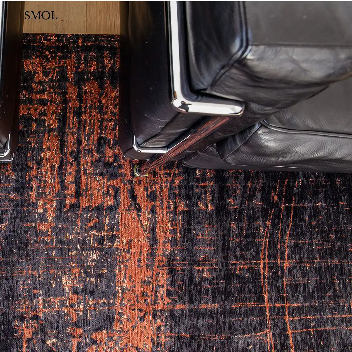 ECO RUG SOHO COPPER absztrakt mintás szőnyeg barna alapon réz-fekete akcentusokkal, fotellel, felülről