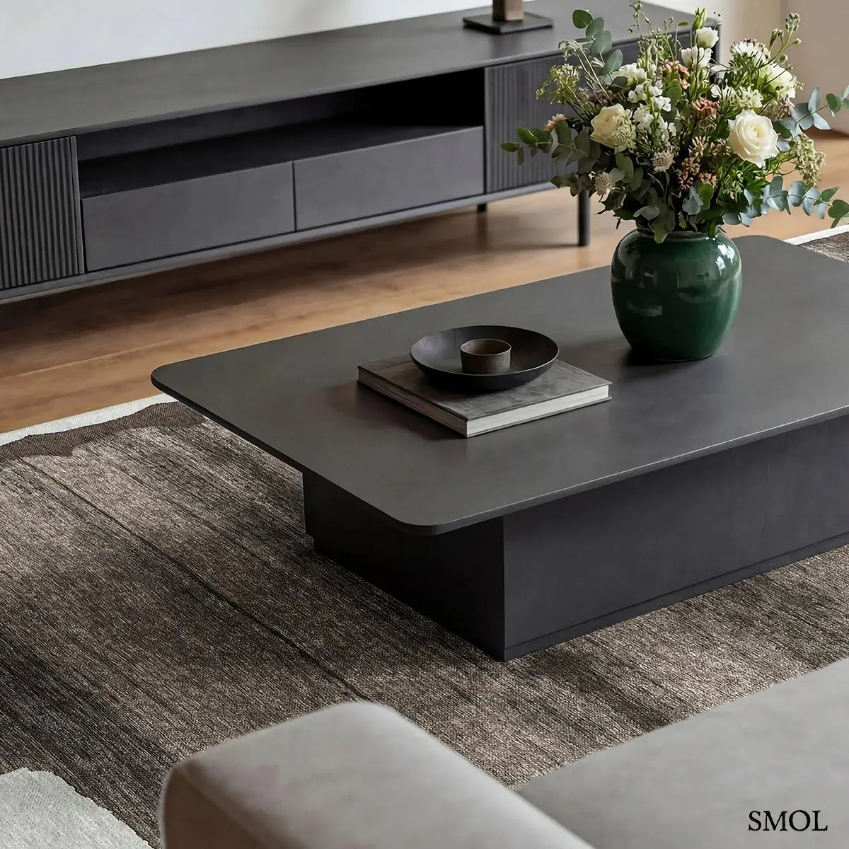 ECO RUG MASTIC absztrakt szőnyeg fehér alapon taupe-barna vízszintes rétegű festői mintával, nappaliban, dohányzóasztal alatt