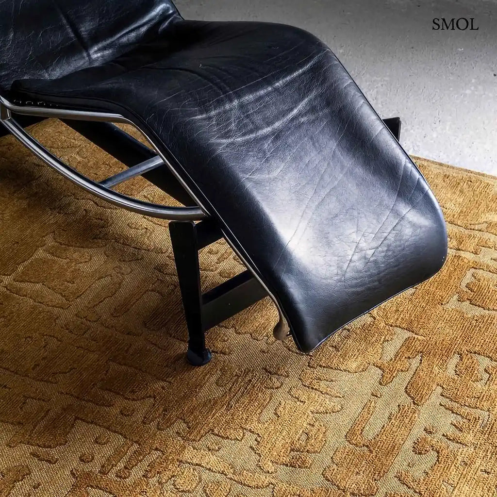 ECO RUG MADAGASCAR GOLD baobab mintás szőnyeg arany-mustár tónusokban, kéregszerű afrikai textúrával, fotellel, nagyítva