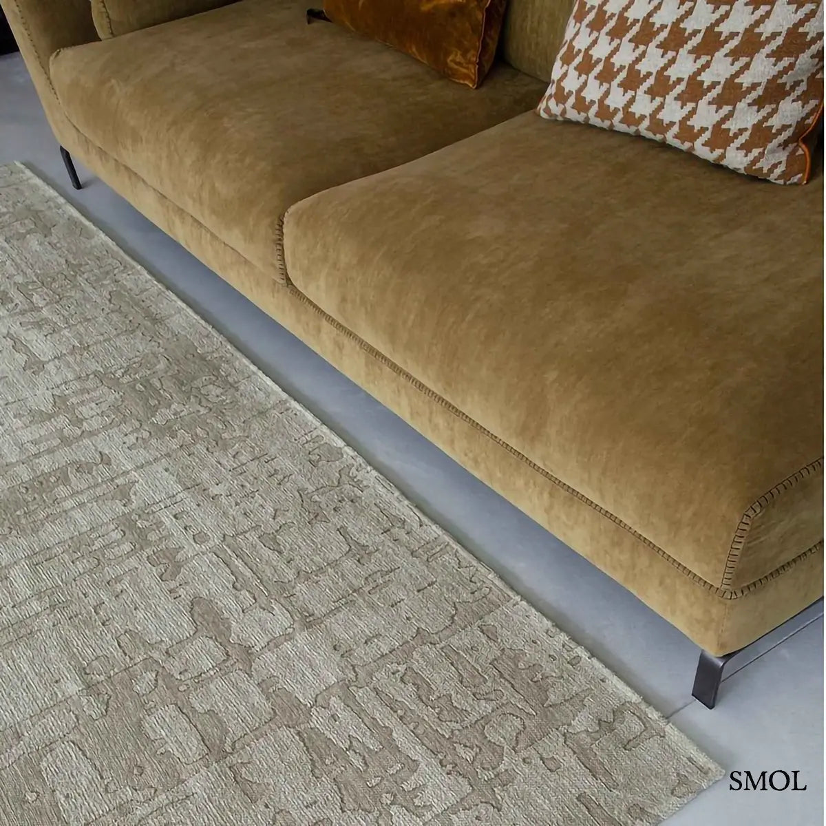 ECO RUG DRY BEIGE baobab mintás szőnyeg bézs-szürke tónusokban, halvány kéregszerű afrikai textúrával, kanapéval nagyítva