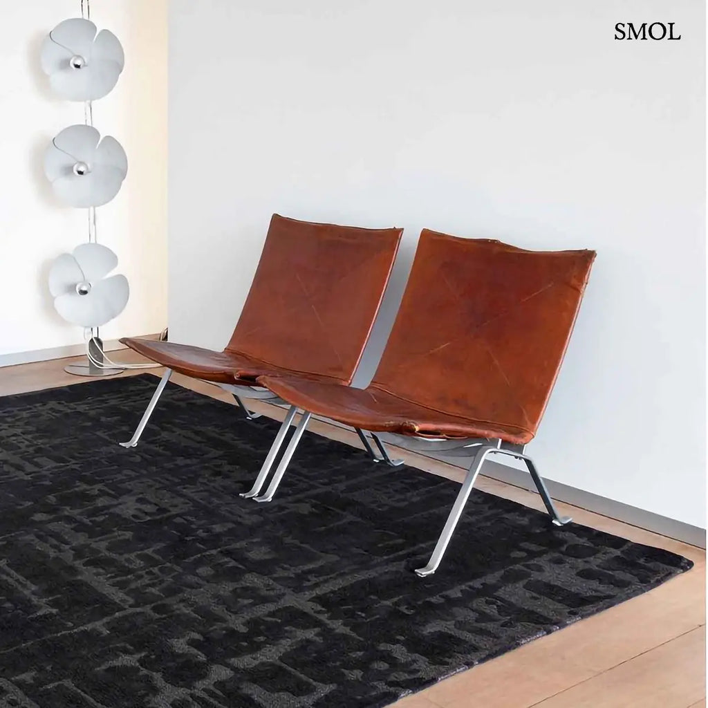 ECO RUG BLACK WATER baobab mintás szőnyeg fekete-antracit tónusokban, kéregszerű afrikai textúrával, két fotellel