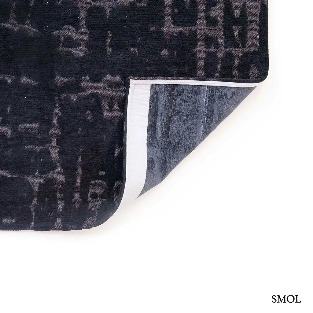 ECO RUG BLACK WATER baobab mintás szőnyeg fekete-antracit tónusokban, kéregszerű afrikai textúrával, felhajtott sarokkal