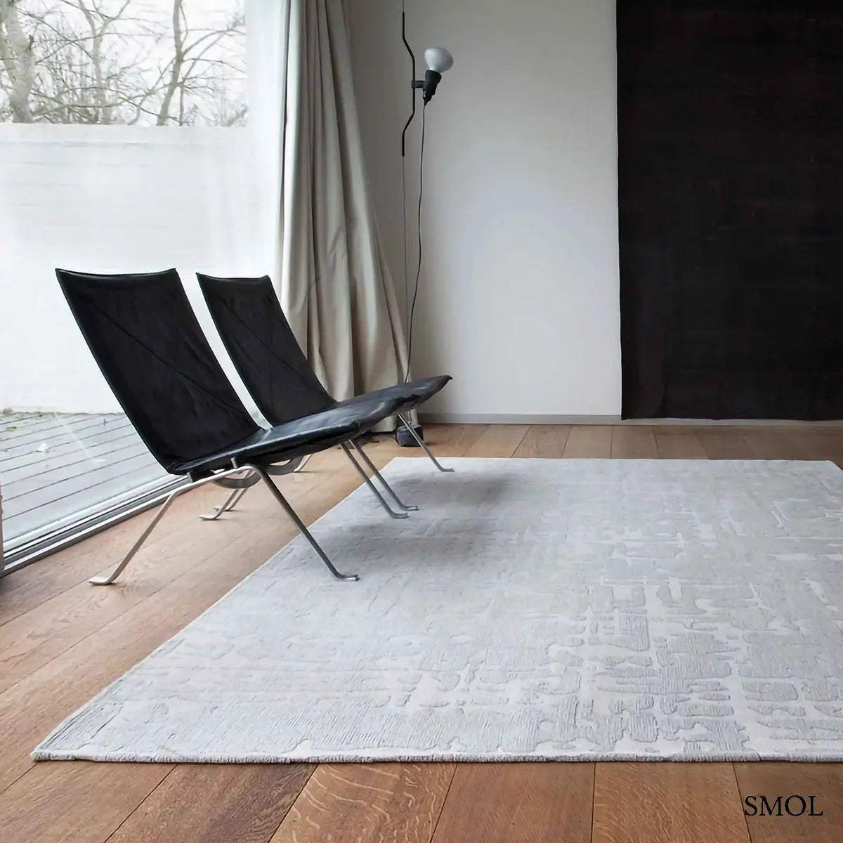 ECO RUG TSINGY OYSTER baobab mintás szőnyeg ezüstszürke tónusokban, halvány kéregszerű afrikai textúrával, nappaliban, fotelekkel