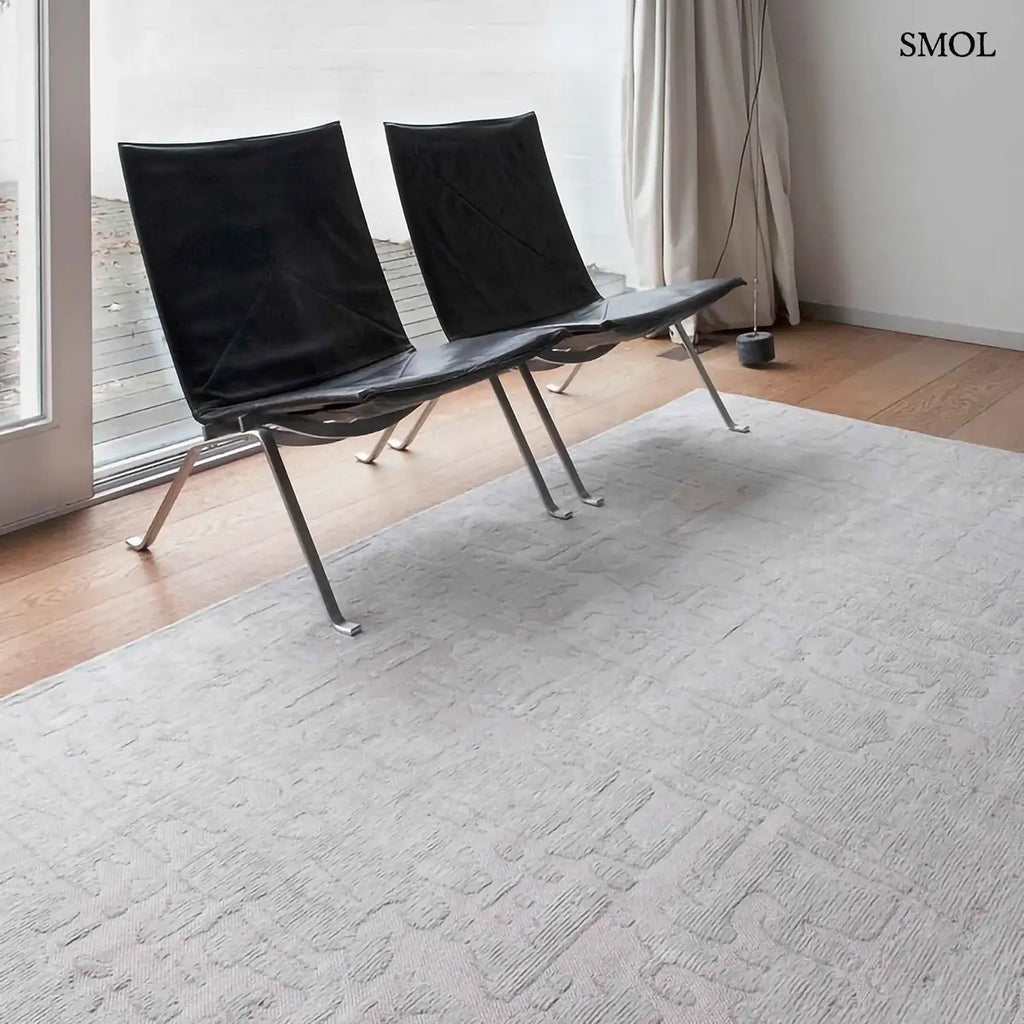 ECO RUG TSINGY OYSTER baobab mintás szőnyeg ezüstszürke tónusokban, halvány kéregszerű afrikai textúrával, fotelekkel, szemből