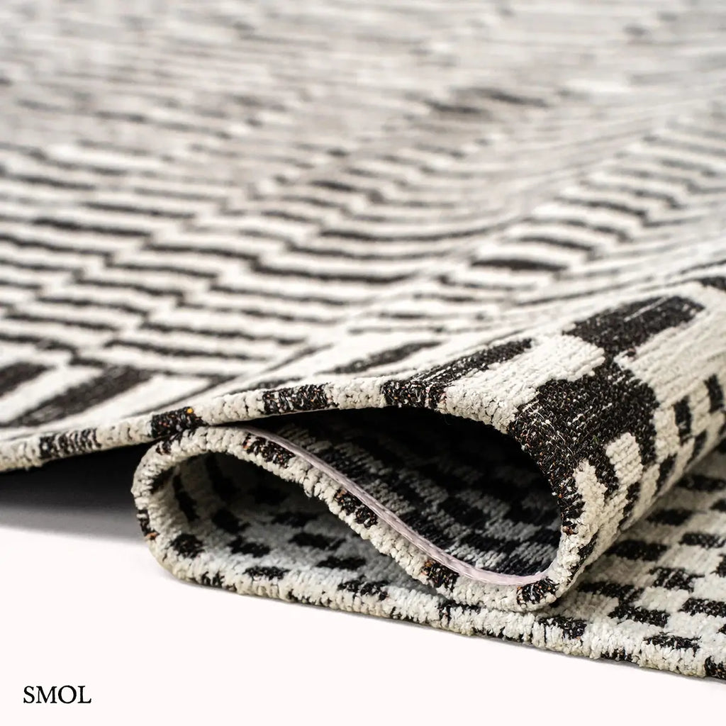 ECO RUG CAIDAL fekete-törtfehér berber mintás szőnyeg, hullámosra hajtogatva