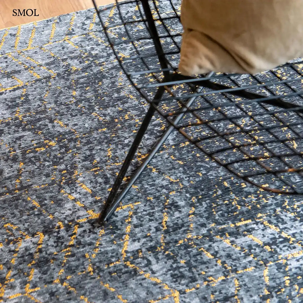 ECO RUG BROADWAY GLITTER chevron mintás szőnyeg fekete-arany kombinációban, csillogó felülettel, pamut-poliészter, fotel alatt nagyítva