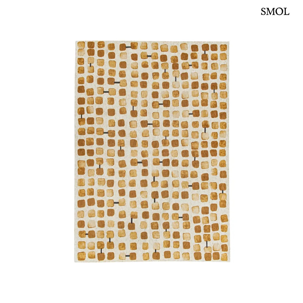 ECO RUG PEACH PARTY geometrikus szőnyeg arany-krém kombinációban, kerekített négyzetes mintával, fekete akcentusokkal, fehér háttérrel