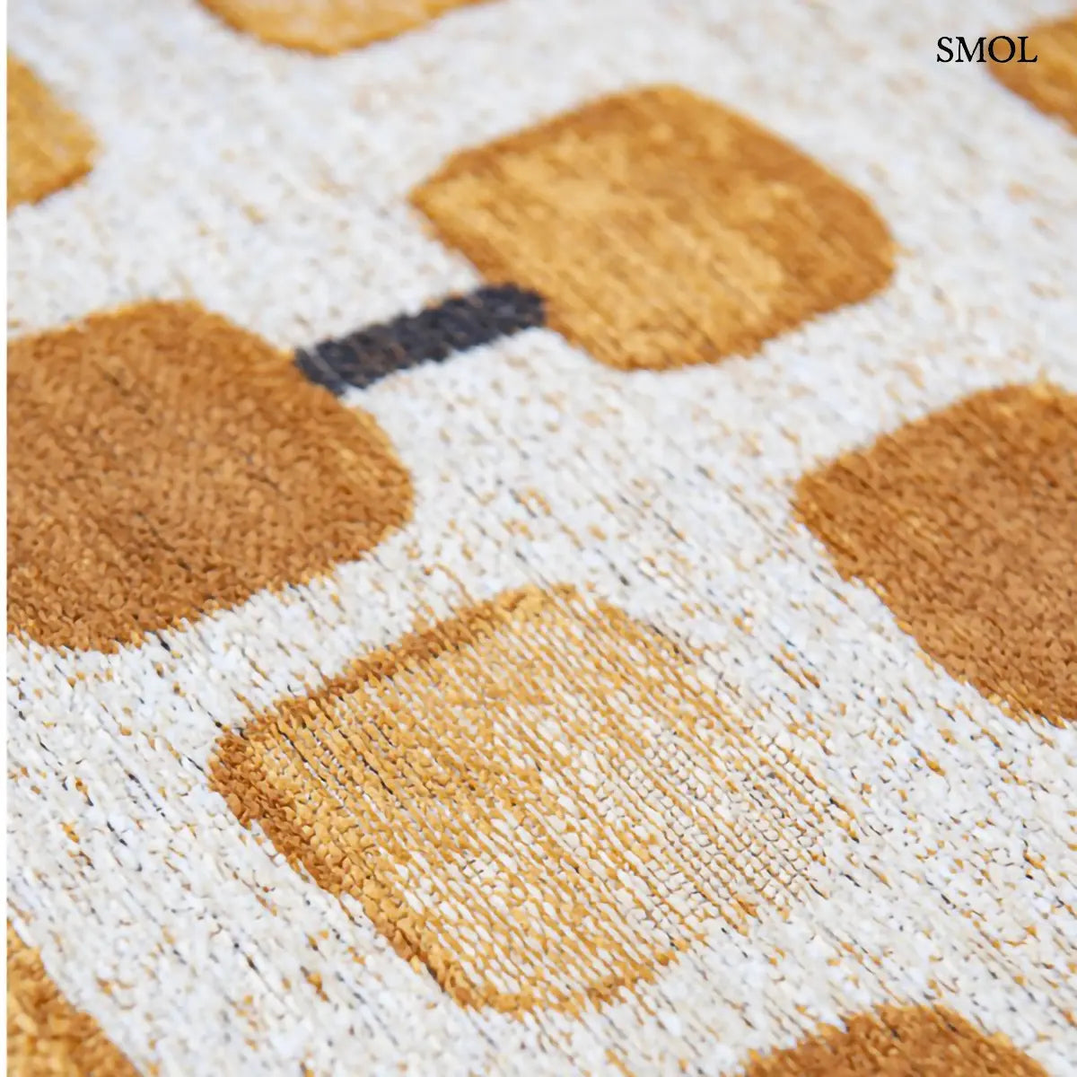 ECO RUG PEACH PARTY geometrikus szőnyeg arany-krém kombinációban, kerekített négyzetes mintával, fekete akcentusokkal, minta nagyítva