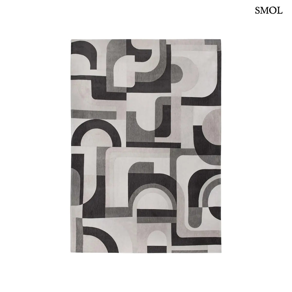 ECO RUG SAXON BEIGE szőnyeg, bézs és sötétszürke geometrikus formákból összeálló, íves-szögletes mintázattal, fehér háttérrel