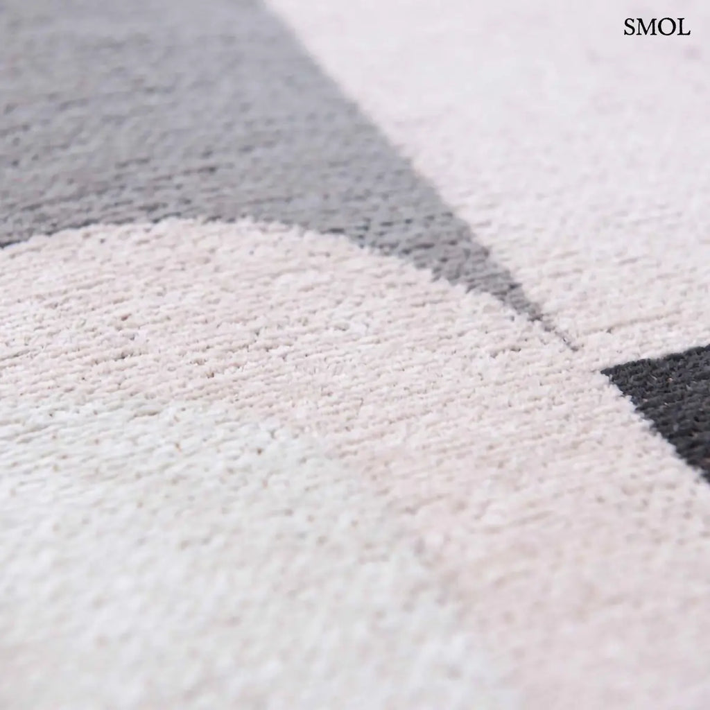 ECO RUG SAXON BEIGE szőnyeg, bézs és sötétszürke geometrikus formákból összeálló, íves-szögletes mintázattal, textúra nagyítva