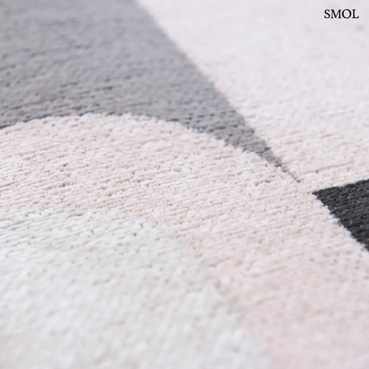 ECO RUG SAXON BEIGE szőnyeg, bézs és sötétszürke geometrikus formákból összeálló, íves-szögletes mintázattal, textúra nagyítva