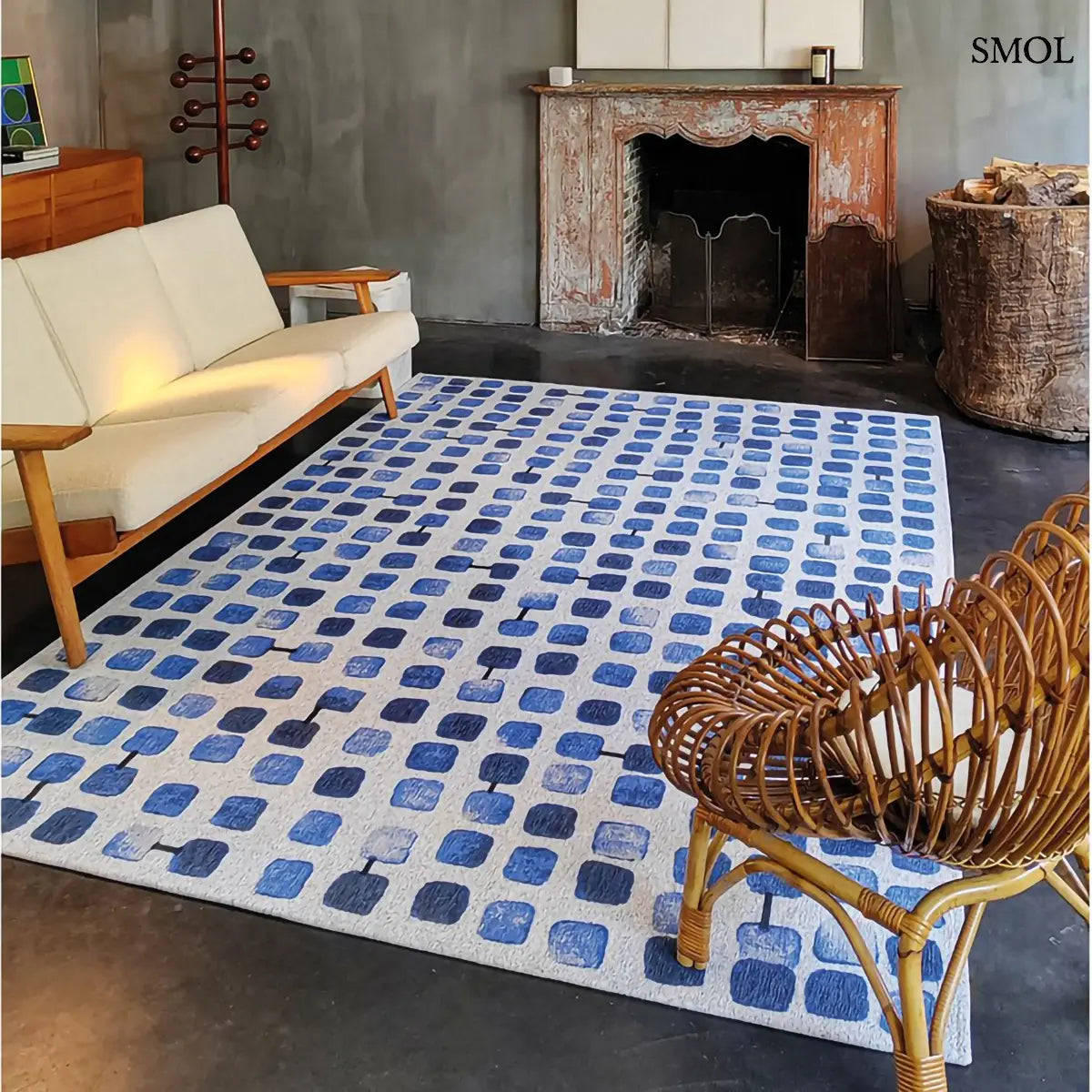 ECO RUG AMPARO BLUES geometrikus szőnyeg kék-fehér kombinációban, kerekített négyzetes mintával, fekete akcentusokkal, nappaliban, kandallóval