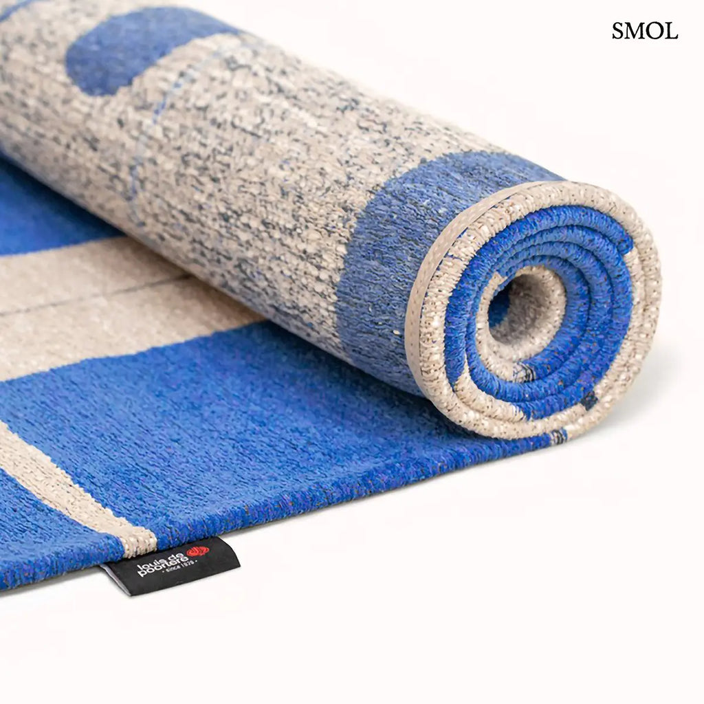 ECO RUG CAMPANULA geometrikus mintás szőnyeg kék-fehér tónusokban, Bauhaus ihletésű formavilággal, feltekerve