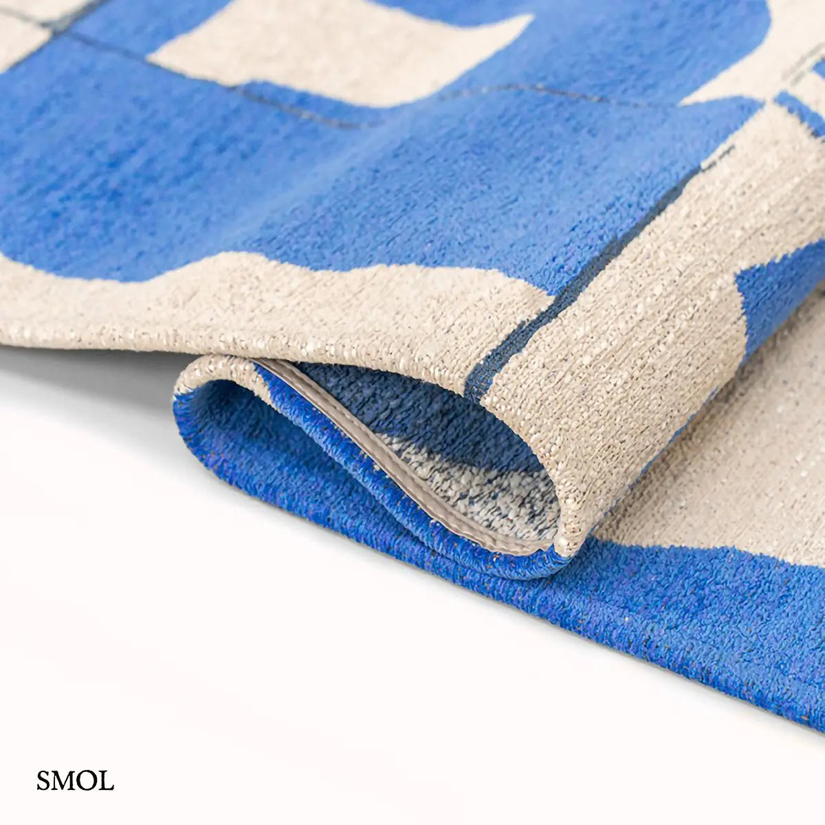 ECO RUG CAMPANULA geometrikus mintás szőnyeg kék-fehér tónusokban, Bauhaus ihletésű formavilággal, hullámosra hajtogatva