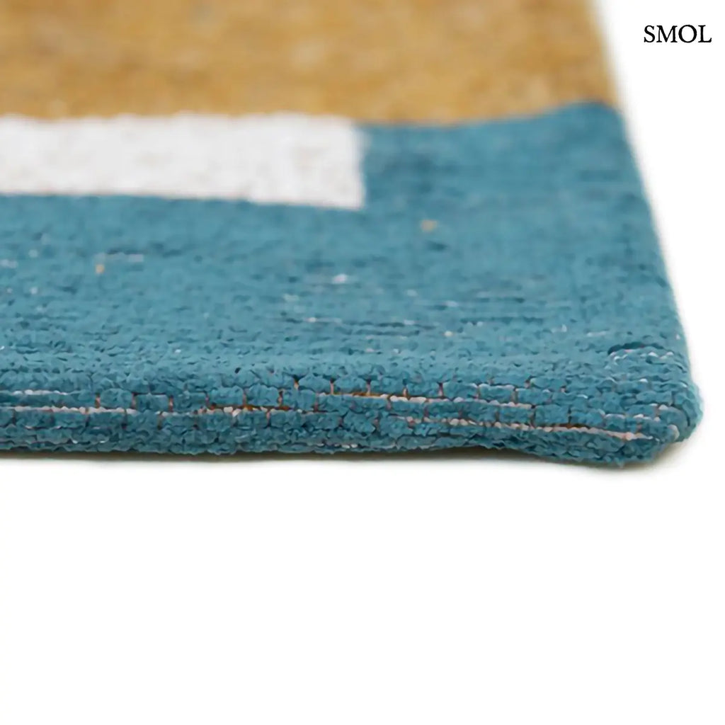 ECO RUG HONEY geometrikus szőnyeg mustársárga-krém kombinációban, dekonstruált sakktábla mintával, kék szegéllyel, újrahasznosított poliészter vastagság nagyítva