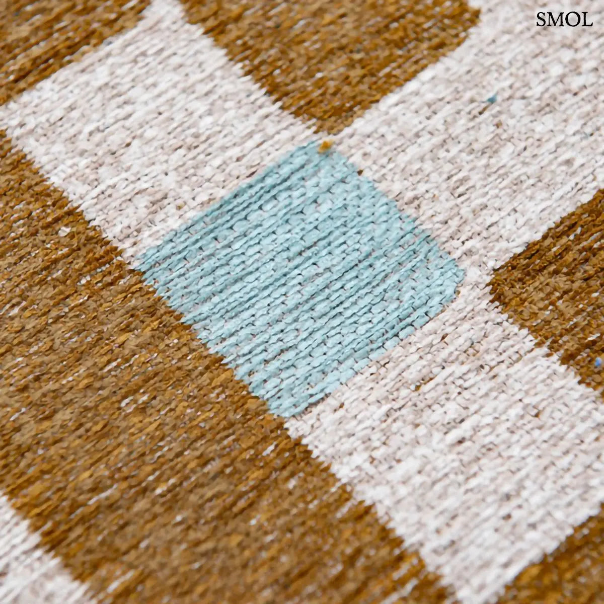 ECO RUG HONEY geometrikus szőnyeg mustársárga-krém kombinációban, dekonstruált sakktábla mintával, kék szegéllyel, újrahasznosított poliészter nagyítva