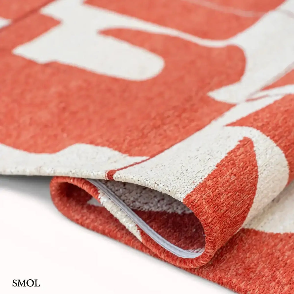 ECO RUG RUST piros geometrikus mintás szőnyeg, hullámosra hajtogatva