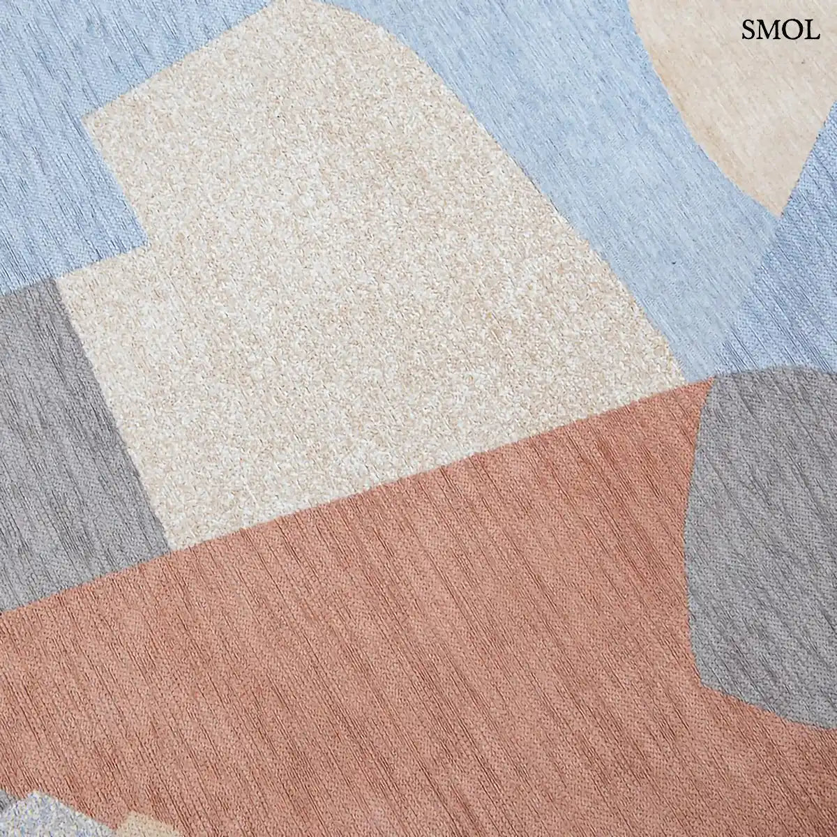 ECO RUG SECRET szőnyeg, narancs, kék, szürke és bézs geometrikus formákból összeálló, egymásba fonódó mintázattal, minta nagyítva