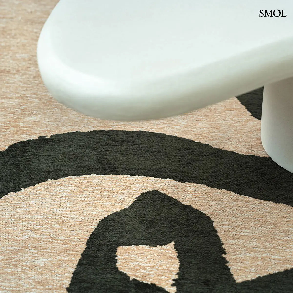 ECO RUG GARDEN SPIRIT kalligráfia mintás szőnyeg bézs alapon sötétzöld expresszív vonalakkal, fehér asztal alatt nagyítva