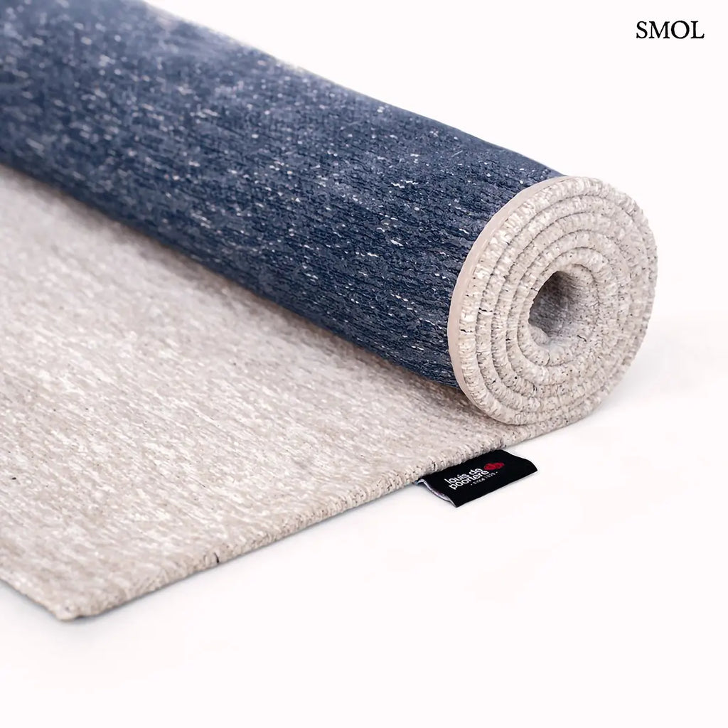 ECO RUG SEA INK kalligráfia mintás szőnyeg krém alapon sötétkék táncoló vonalakkal, feltekerve