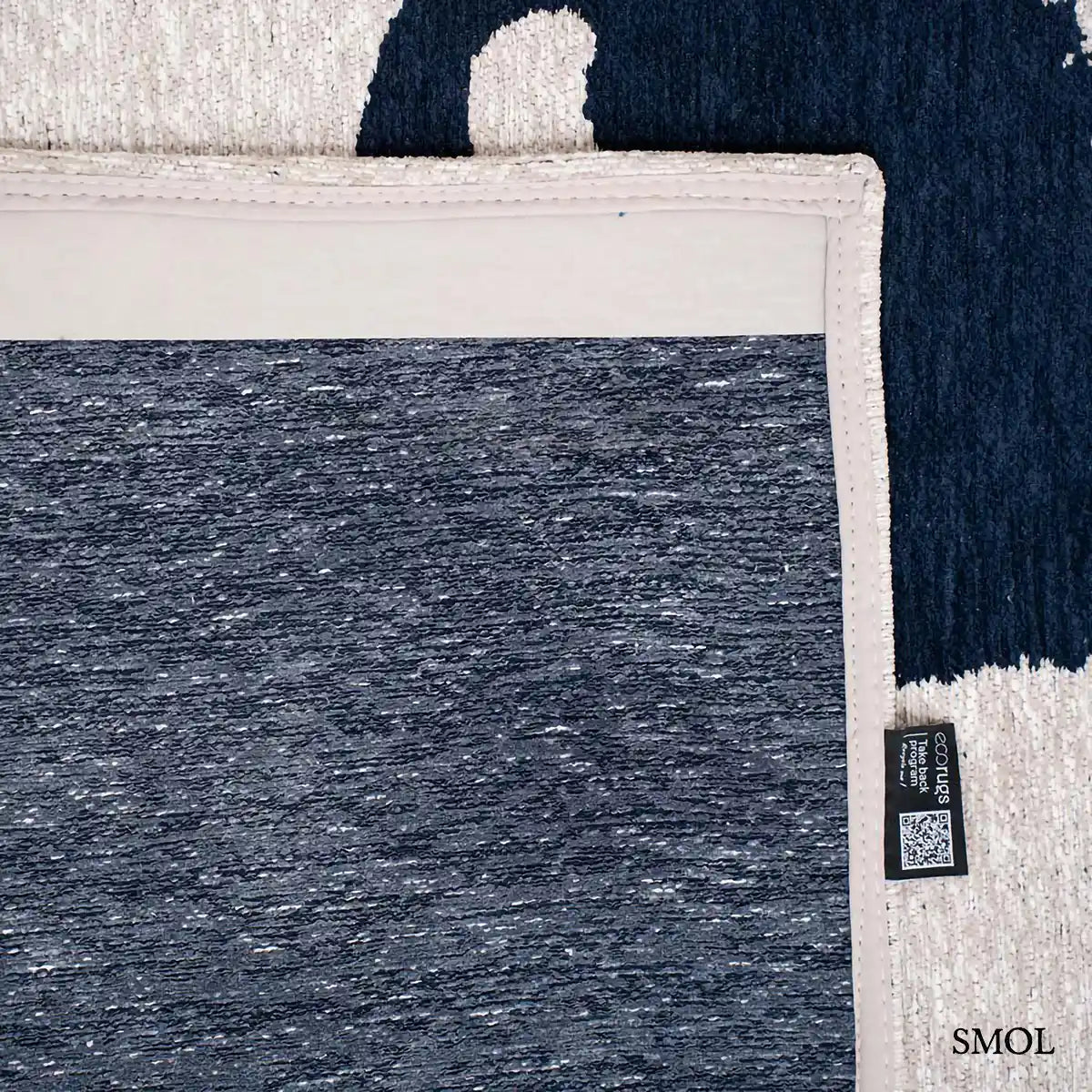 ECO RUG SEA INK kalligráfia mintás szőnyeg krém alapon sötétkék táncoló vonalakkal, felhajtott sarokkal, hátulról
