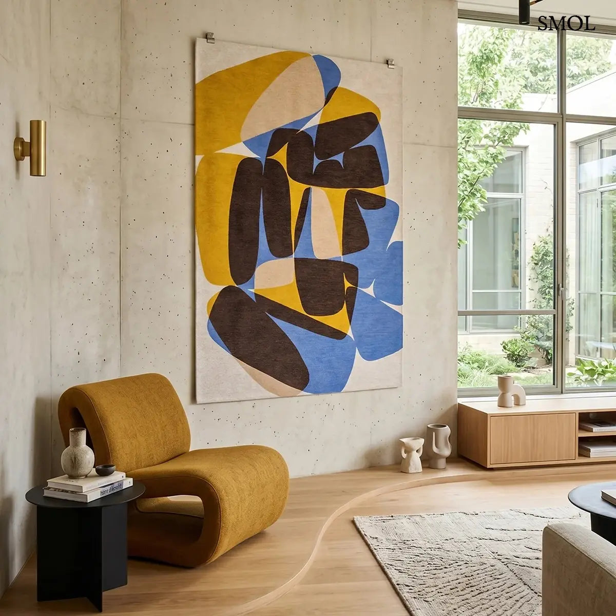 ECO RUG SUNNY BLUE szőnyeg, kék, sárga és barna kavicsszerű formákból álló, egymást átfedő mintázattal, falon