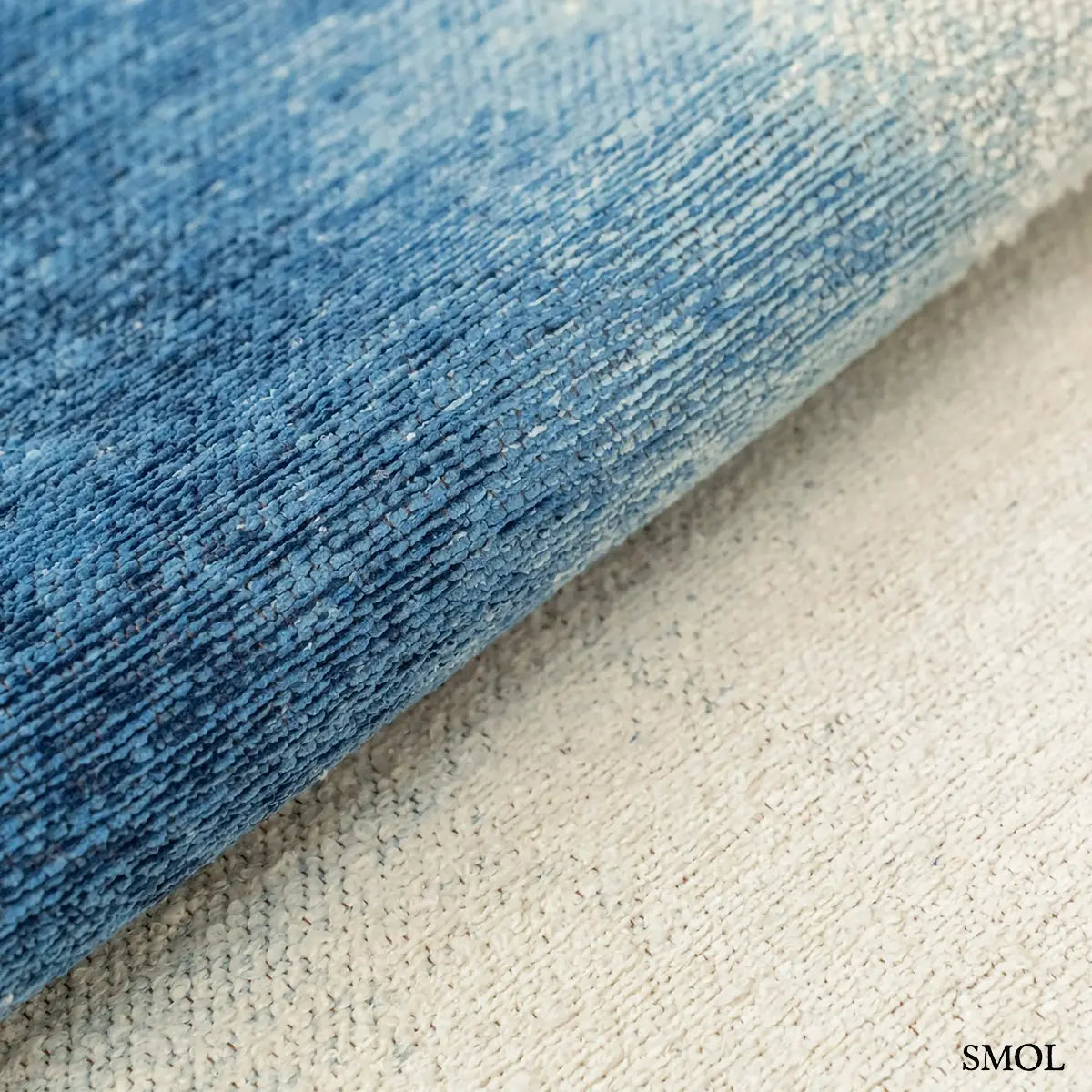 ECO RUG DREAM IN BLUE szőnyeg fehér alapon mélykék festékrobbanás-szerű folttal, halvány kék átmenettel, textúra nagyítva