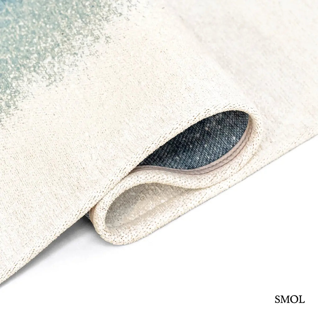 ECO RUG DREAM IN BLUE szőnyeg fehér alapon mélykék festékrobbanás-szerű folttal, halvány kék átmenettel, hullámosan hajtogatva
