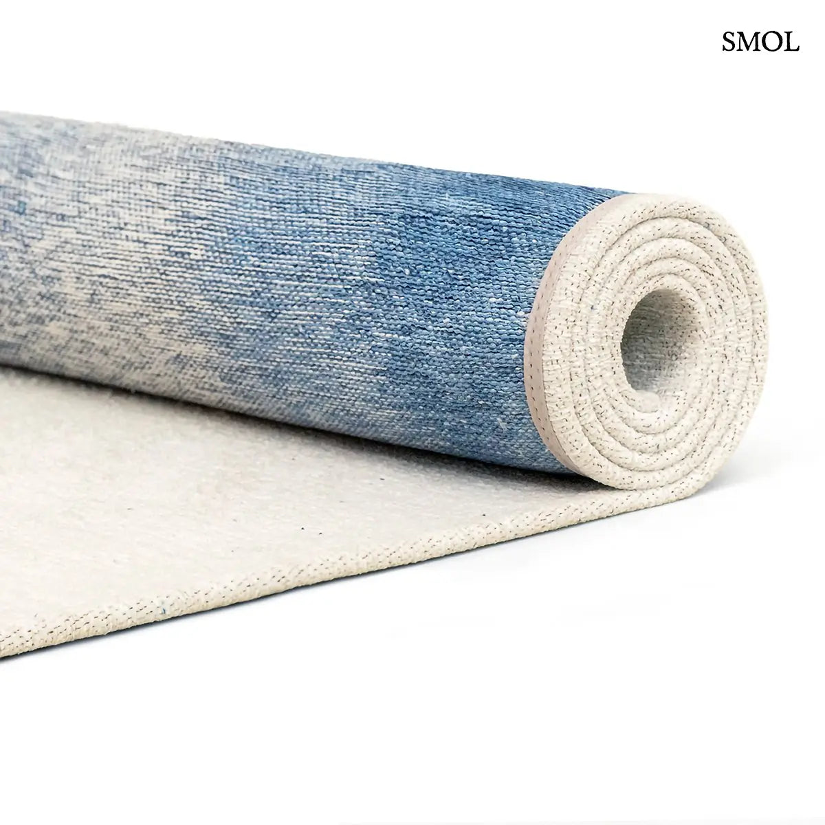 ECO RUG DREAM IN BLUE szőnyeg fehér alapon mélykék festékrobbanás-szerű folttal, halvány kék átmenettel, feltekerve