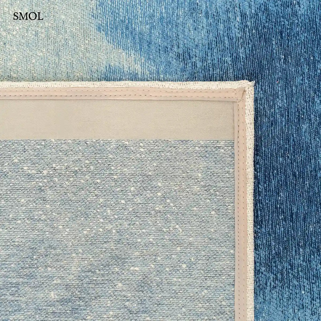 ECO RUG DREAM IN BLUE szőnyeg fehér alapon mélykék festékrobbanás-szerű folttal, halvány kék átmenettel, felhajtott sarokkal