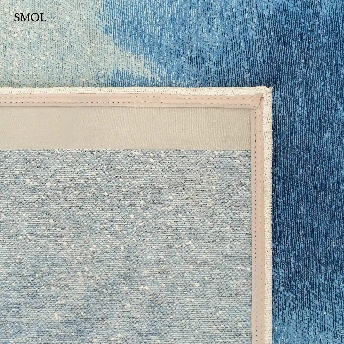 ECO RUG DREAM IN BLUE szőnyeg fehér alapon mélykék festékrobbanás-szerű folttal, halvány kék átmenettel, felhajtott sarokkal