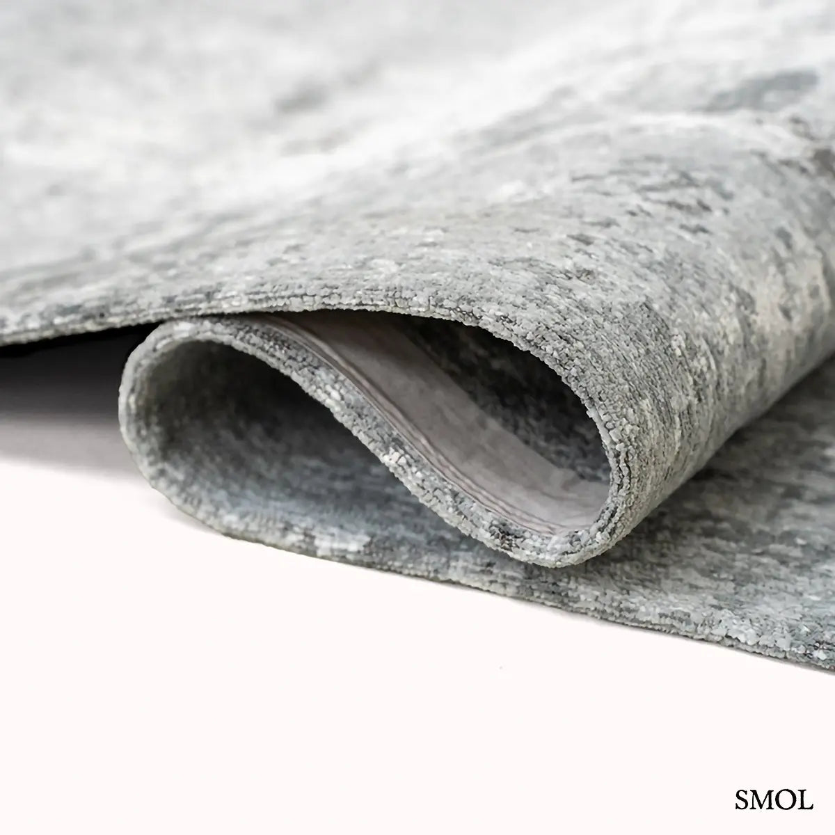 ECO RUG VENUS puha szürke kráteres mintás szőnyeg, hullámosra hajtogatva