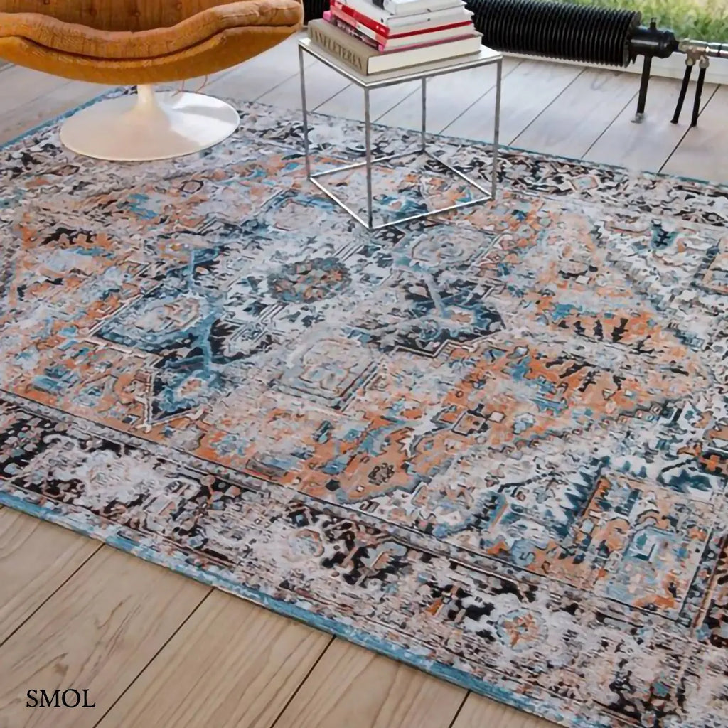 ECO RUG SERAY ORANGE perzsa mintás szőnyeg narancssárga alapon fekete-kék Heriz mintával, koptatott vintage hatással, nappaliban, fotellel