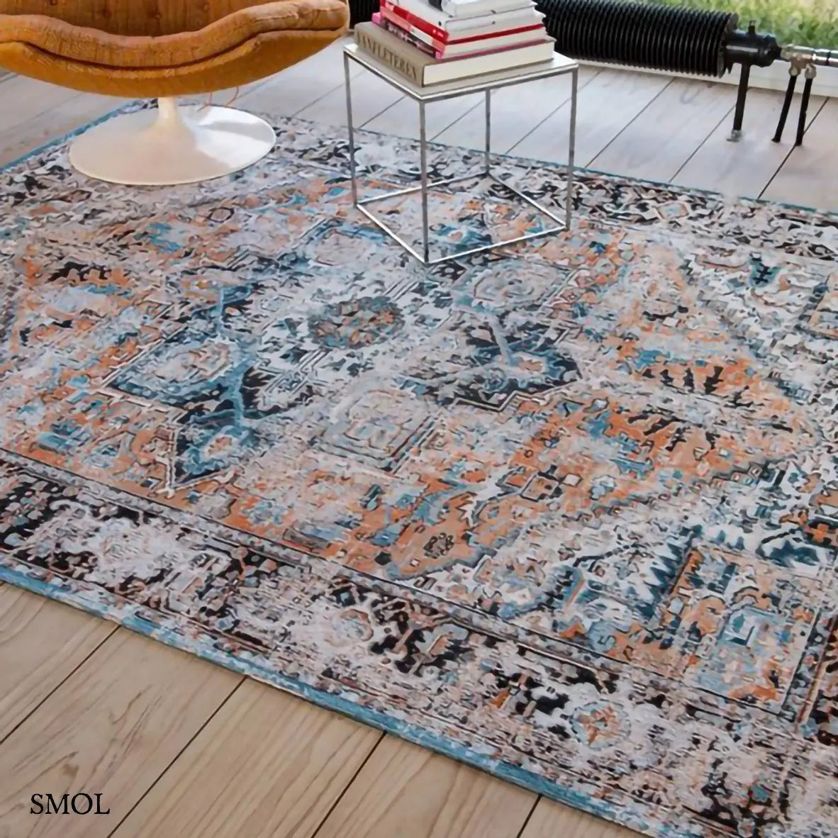ECO RUG SERAY ORANGE perzsa mintás szőnyeg narancssárga alapon fekete-kék Heriz mintával, koptatott vintage hatással, nappaliban, fotellel
