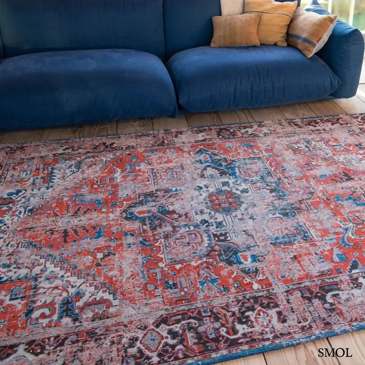 ECO RUG CLASSIC BRICK perzsa mintás szőnyeg piros alapon kék Heriz medallion mintával, koptatott vintage hatással, nappaliban, kék kanapé előtt