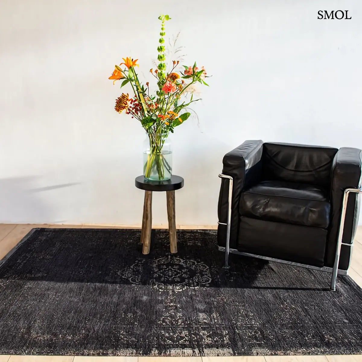 ECO RUG MINERAL BLACK perzsa mintás szőnyeg vintage hatással, fekete-antracit színben, jacquard Wilton szövés, pamut-gyapjú-poliészter, fekete fotellel, virággal