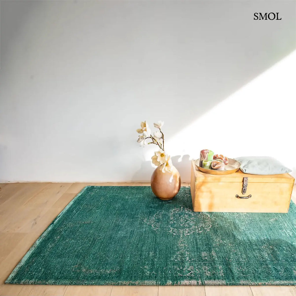 ECO RUG JADE perzsa mintás szőnyeg jadezöld alapon krémszínű koptatott medallion mintával, vintage hatással, jacquard szövés, szobában, vázával és ládával, szemből