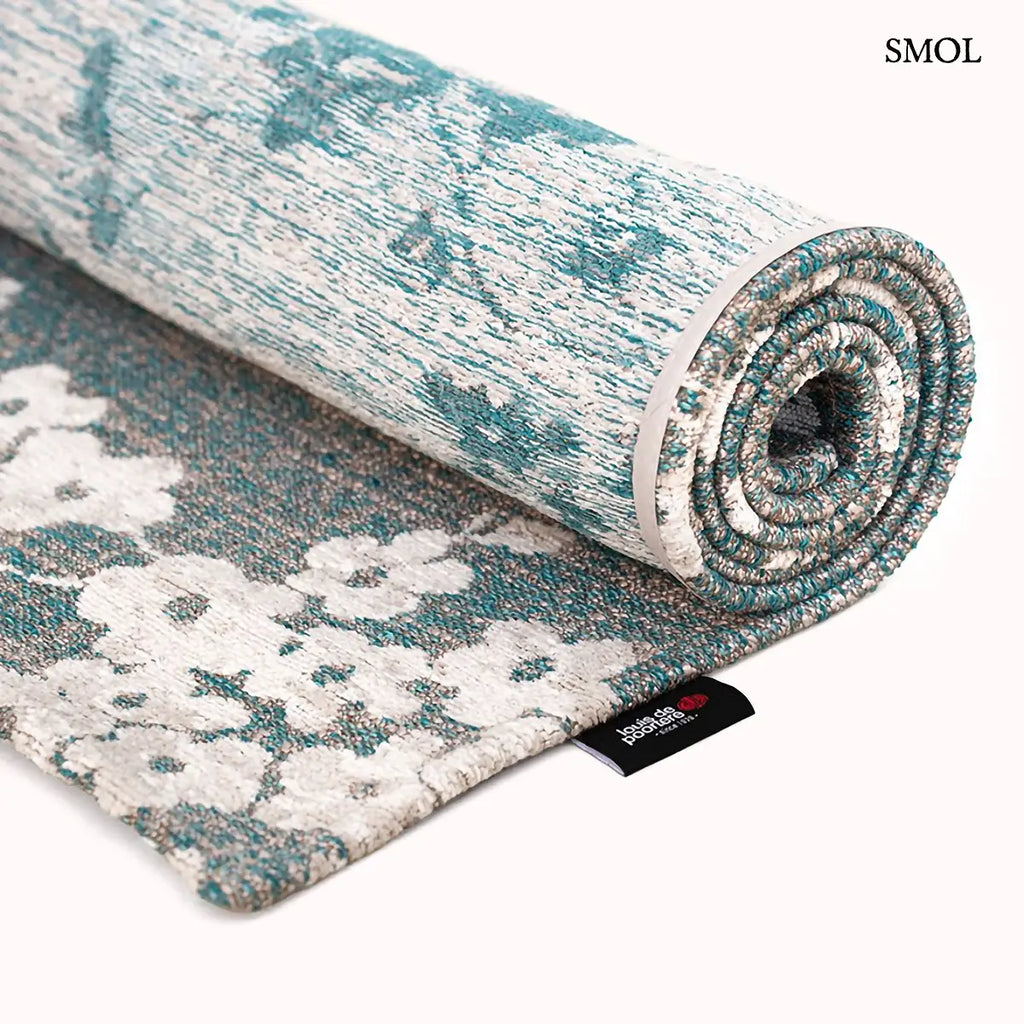 ECO RUG LAKE BLUE sakura mintás szőnyeg türkizkék alapon fehér-krém cseresznyevirág ágakkal, feltekerve