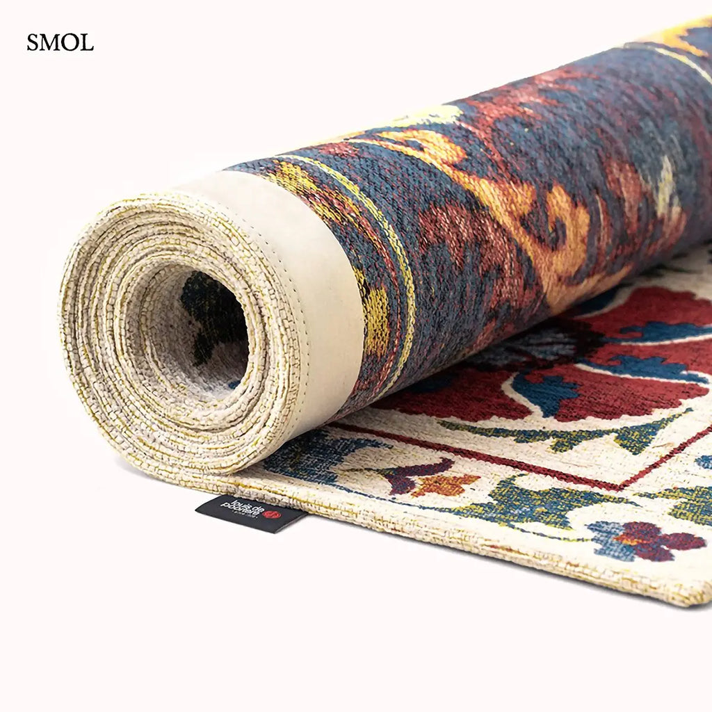 ECO RUG ORIGINE sokszínű suzani mintás szőnyeg krém alapon, közép-ázsiai virágos motívumokkal, feltekerve