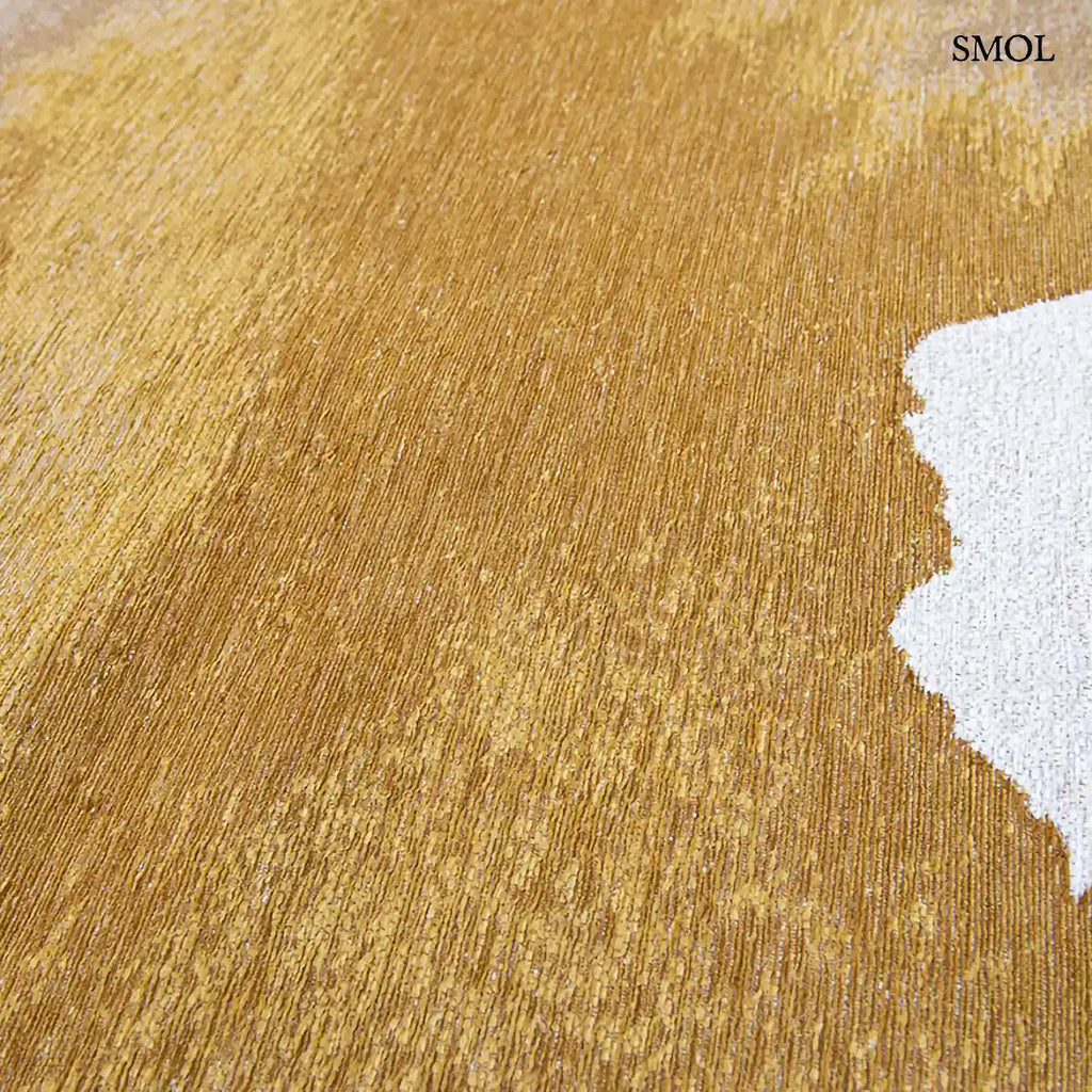 ECO RUG SUNSET szőnyeg, arany és barna színátmenettel, egyik oldalon világosabb szürkés tónusba mosódó tintafolt mintázattal, tintafolt nagyítva