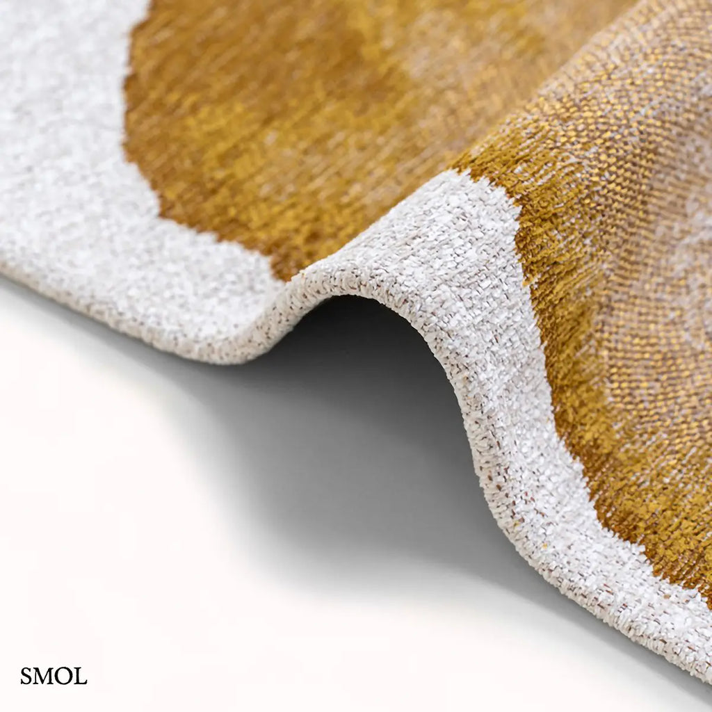 ECO RUG SUNSET szőnyeg, arany és barna színátmenettel, egyik oldalon világosabb szürkés tónusba mosódó tintafolt mintázattal, vastagság nagyítva