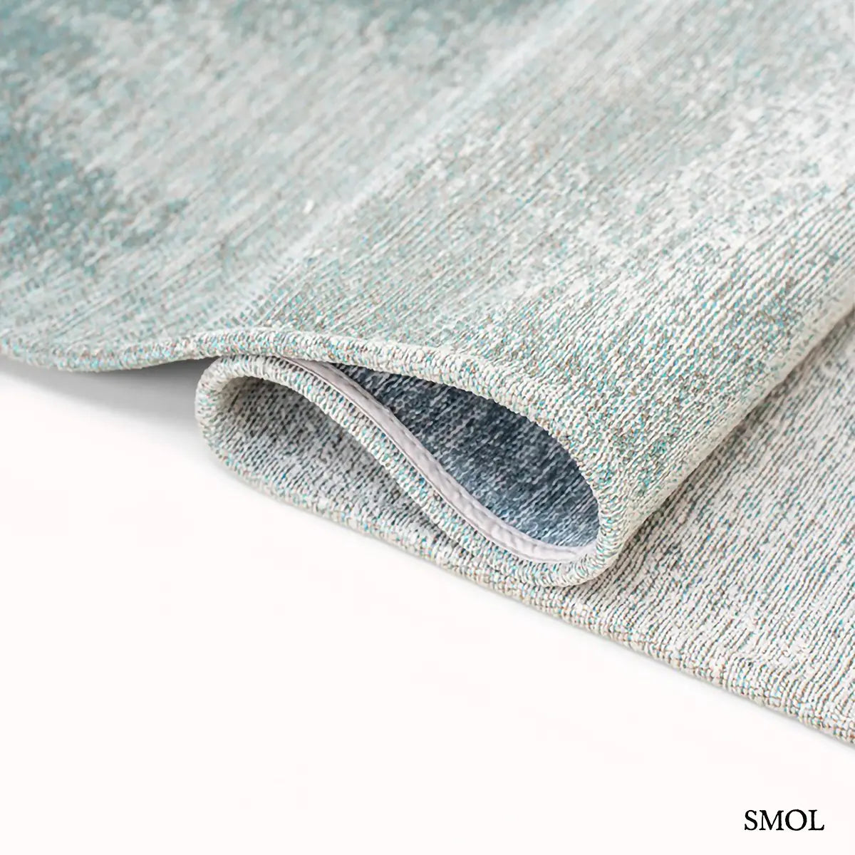 ECO RUG INKJET tintafolt mintás szőnyeg fehér alapon türkiz-kék absztrakt vízfestmény hatással, hullámosra hajtogatva