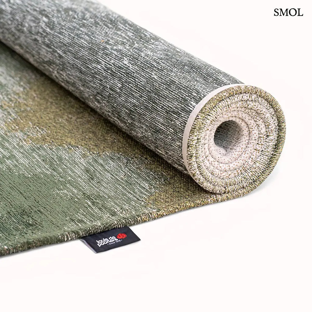 ECO RUG PALM GREEN szőnyeg, sötétzöld színátmenettel, egyik oldalon szinte fehérbe olvadó, mohaszerű tintafolt mintázattal, feltekerve