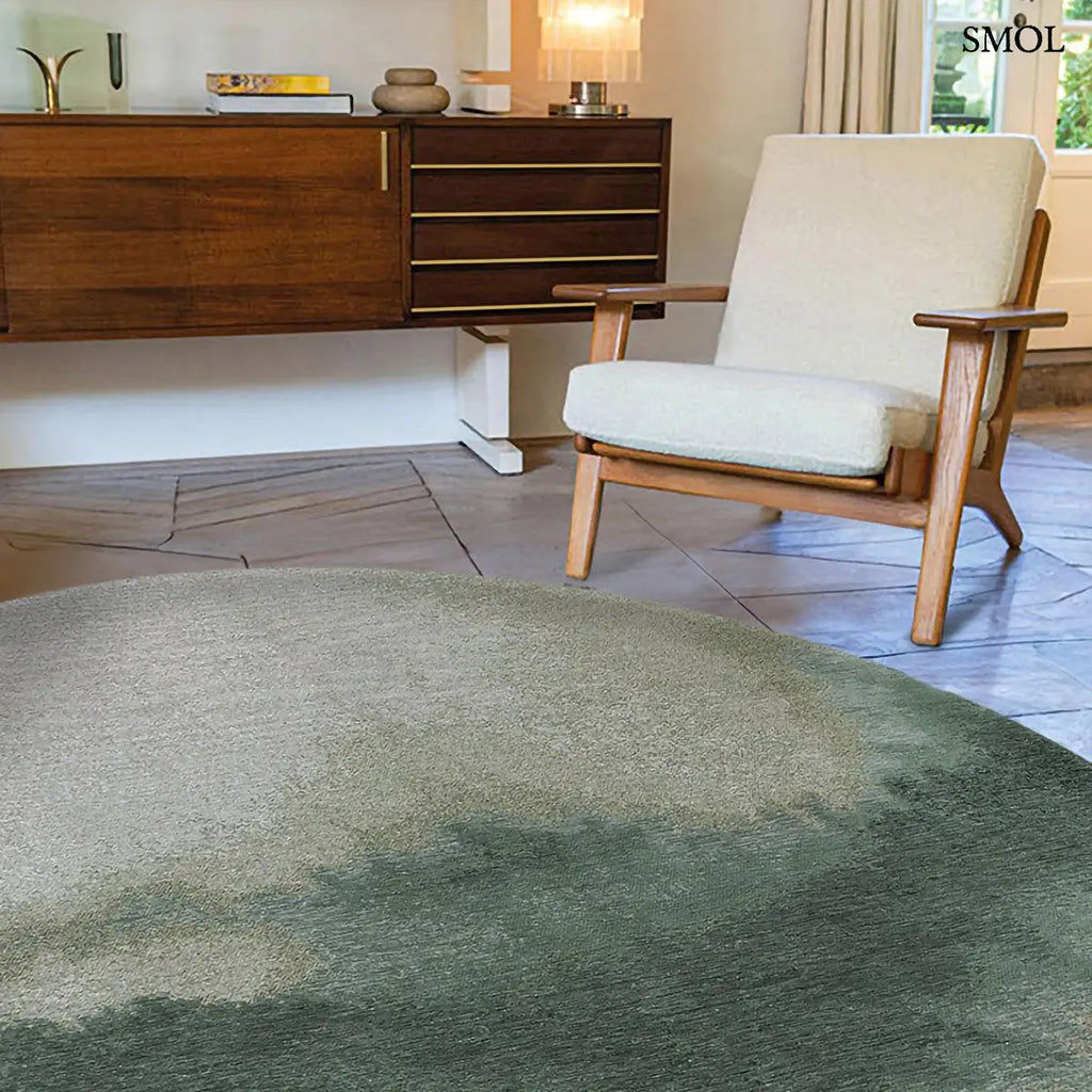 ECO RUG PALM GREEN szőnyeg, sötétzöld színátmenettel, egyik oldalon szinte fehérbe olvadó, mohaszerű tintafolt mintázattal, kerek formában, nappaliban